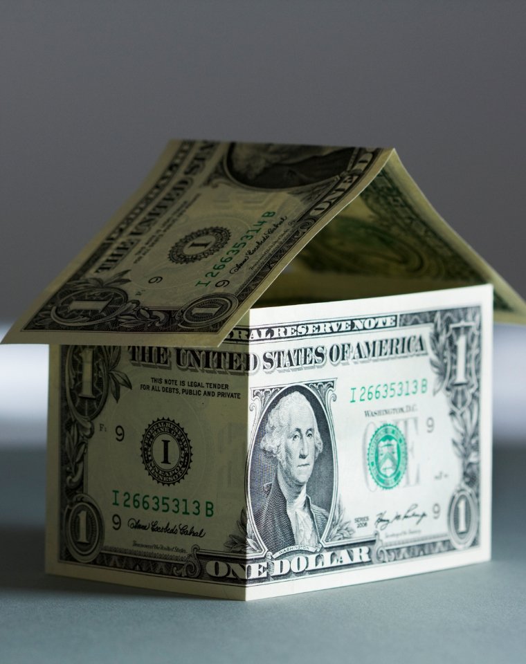 Dollar bills folded into the shape of a house, representing a Grand Junction home value estimate from Flat Five Realty